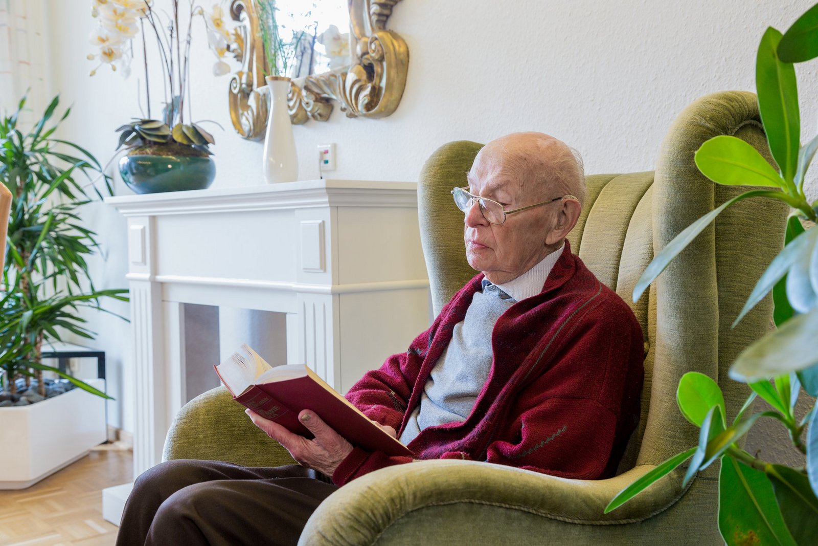 Älterer Herr beim Lesen im Ohrensessel